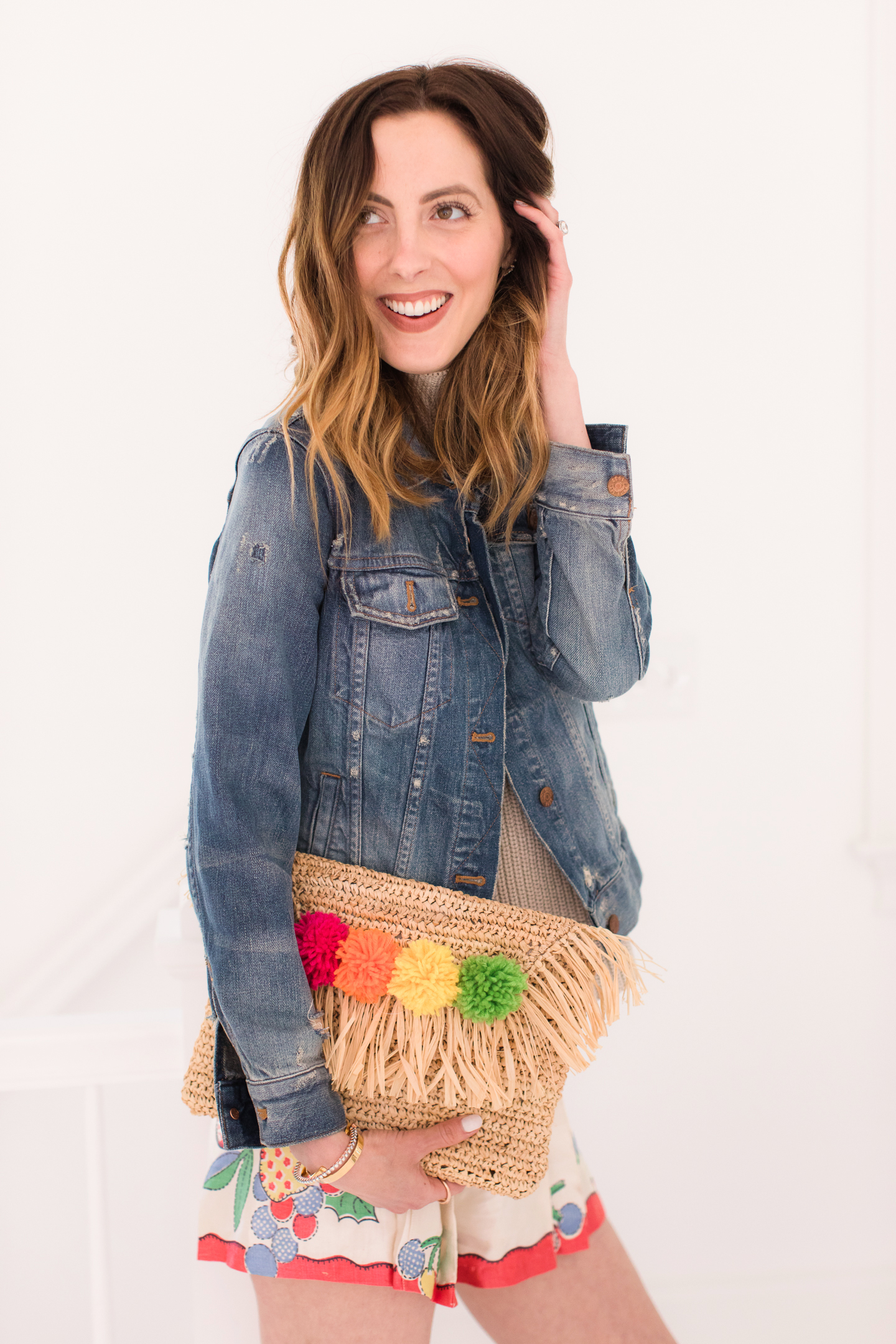 Eva Amurri Martino carries her multicolored DIY pom pom clutch with her colorful summer outfit