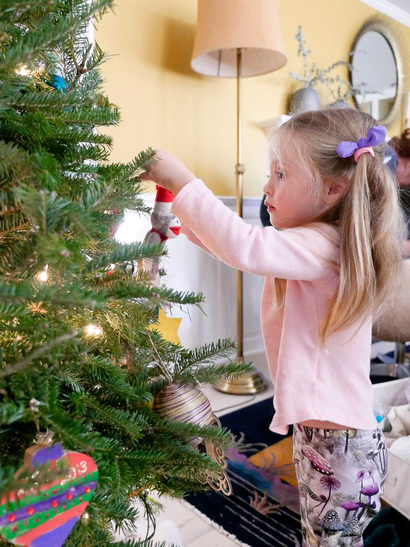 Marlowe Martino hangs an ornament on her family Christmas tree as a Christmas tradition for kids