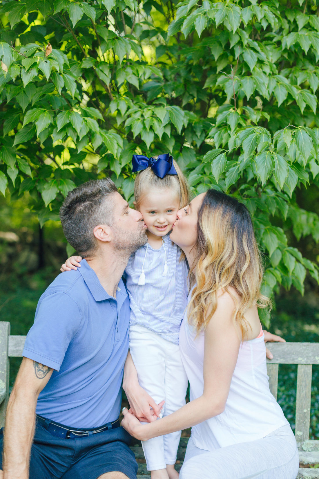 Eva Amurri Martino and Kyle Martino sit on either side of daughter Marlowe and kiss her on the cheeks
