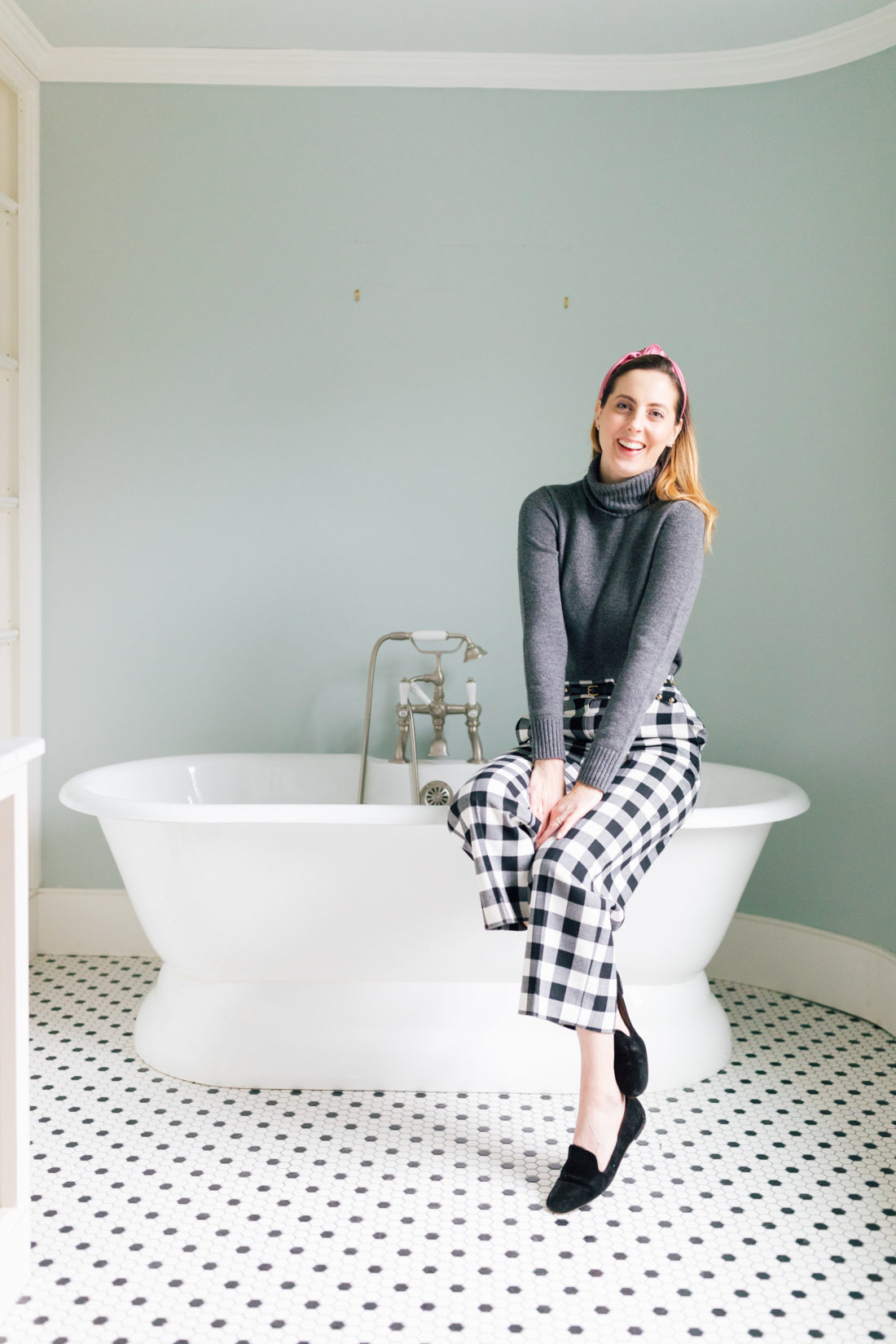Eva Amurri Martino sits on the edge of a bathtub in the bathroom of her new home before renovations