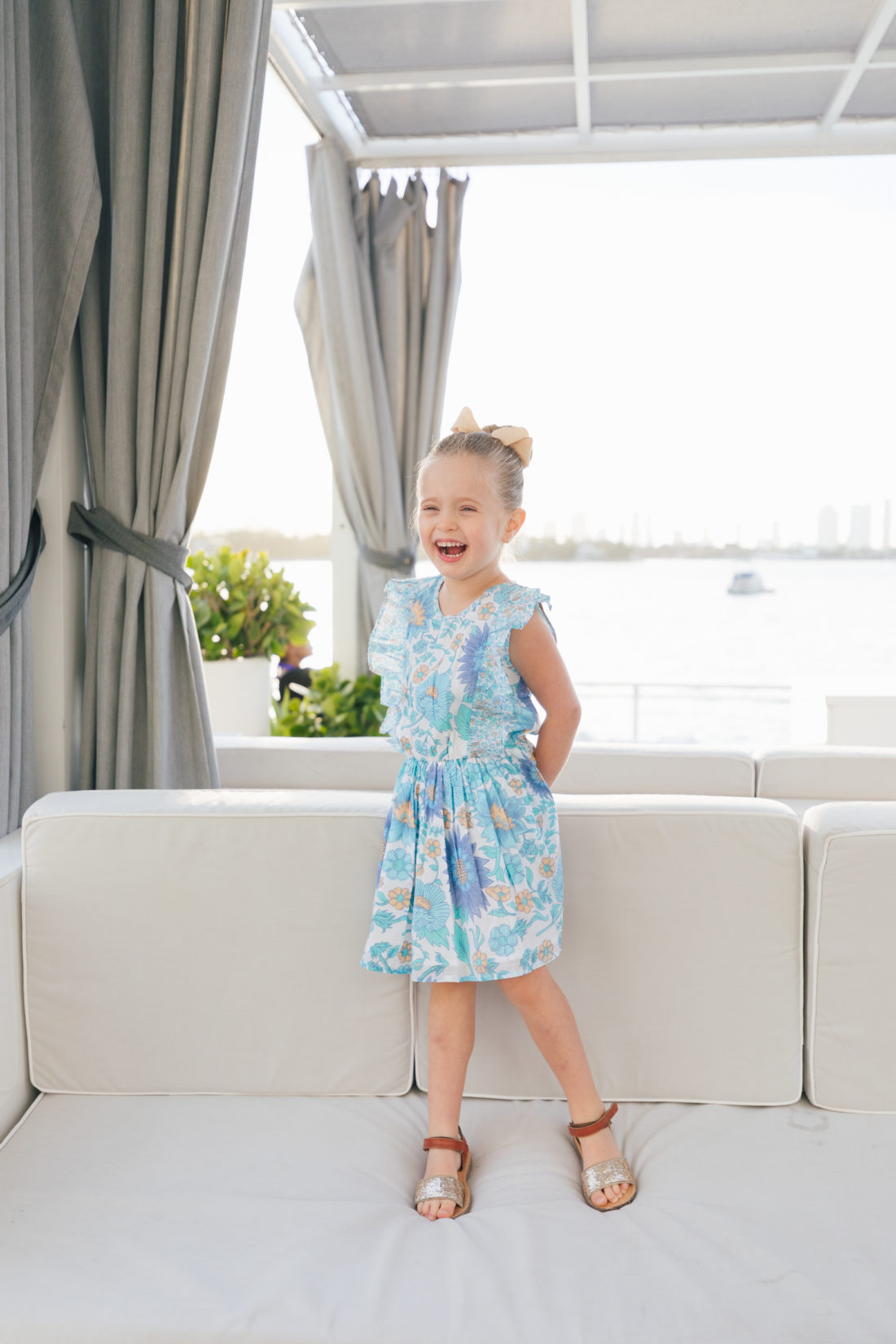 Marlowe Martino laughs while standing in Miami wearing the fantasia dress from the Happily Eva After x Masala Baby capsule collection