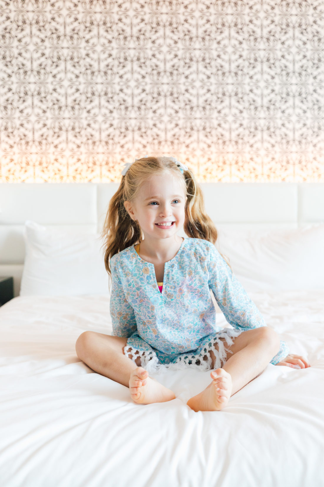 Marlowe Martino poses in her blue floral fringe tunic from the Happily Eva After x Masala Baby collection in a hotel room in Miami