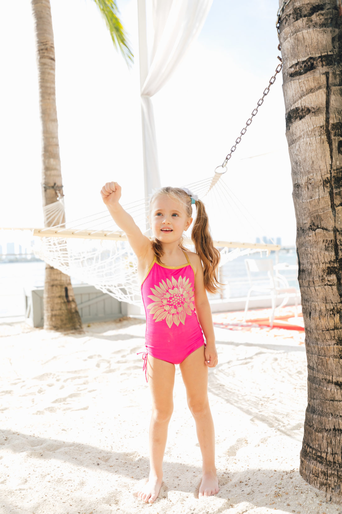 Marlowe Martino wears a pink and gold floral bathing suit on the beach in miami as part of the Happily Eva After x Masala Baby lookbook