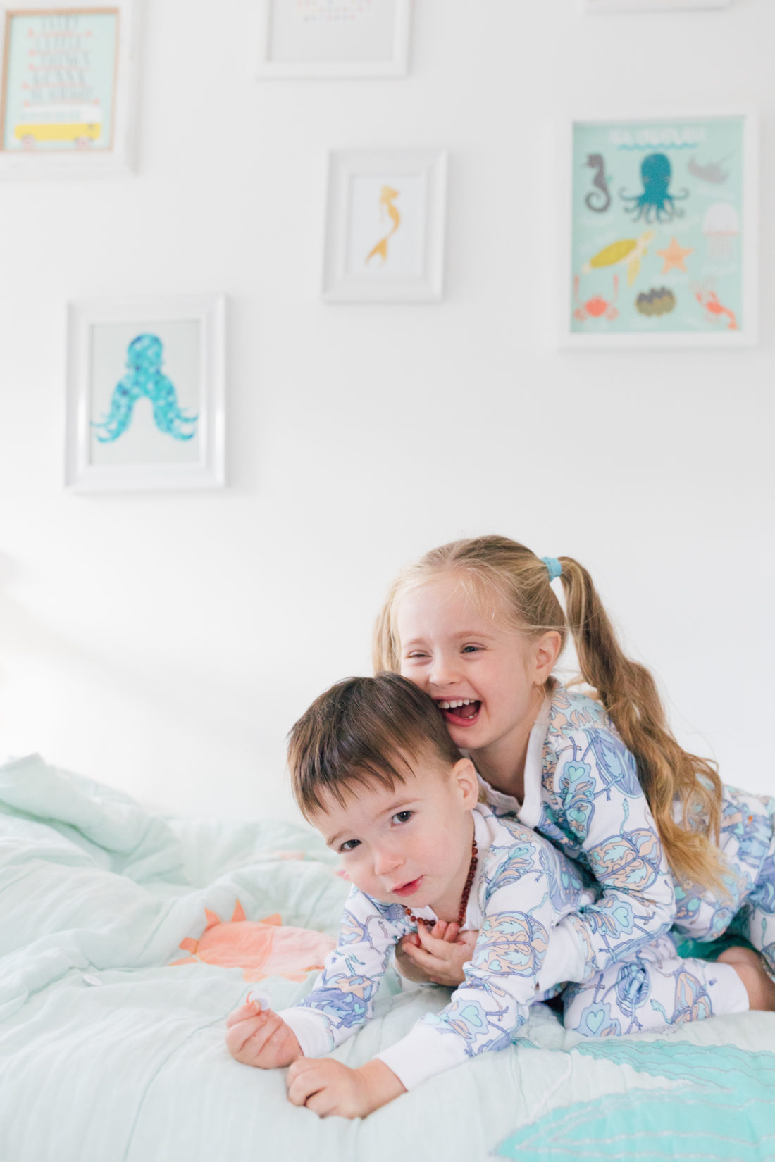 Marlowe Martino gives little brother Major a big hug while wearing matching blue bug pajamas from the Happily Eva After x Masala Baby capsule collection