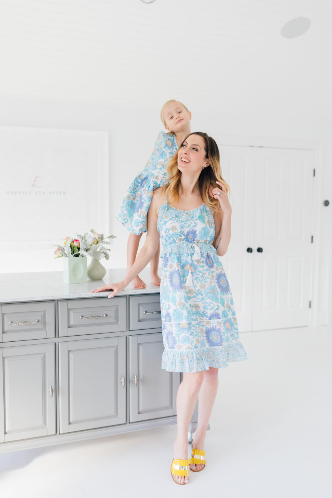 Eva Amurri Martino stands in a floral ruffle dress in the studio of her connecticut home with four year old daughter Marlowe