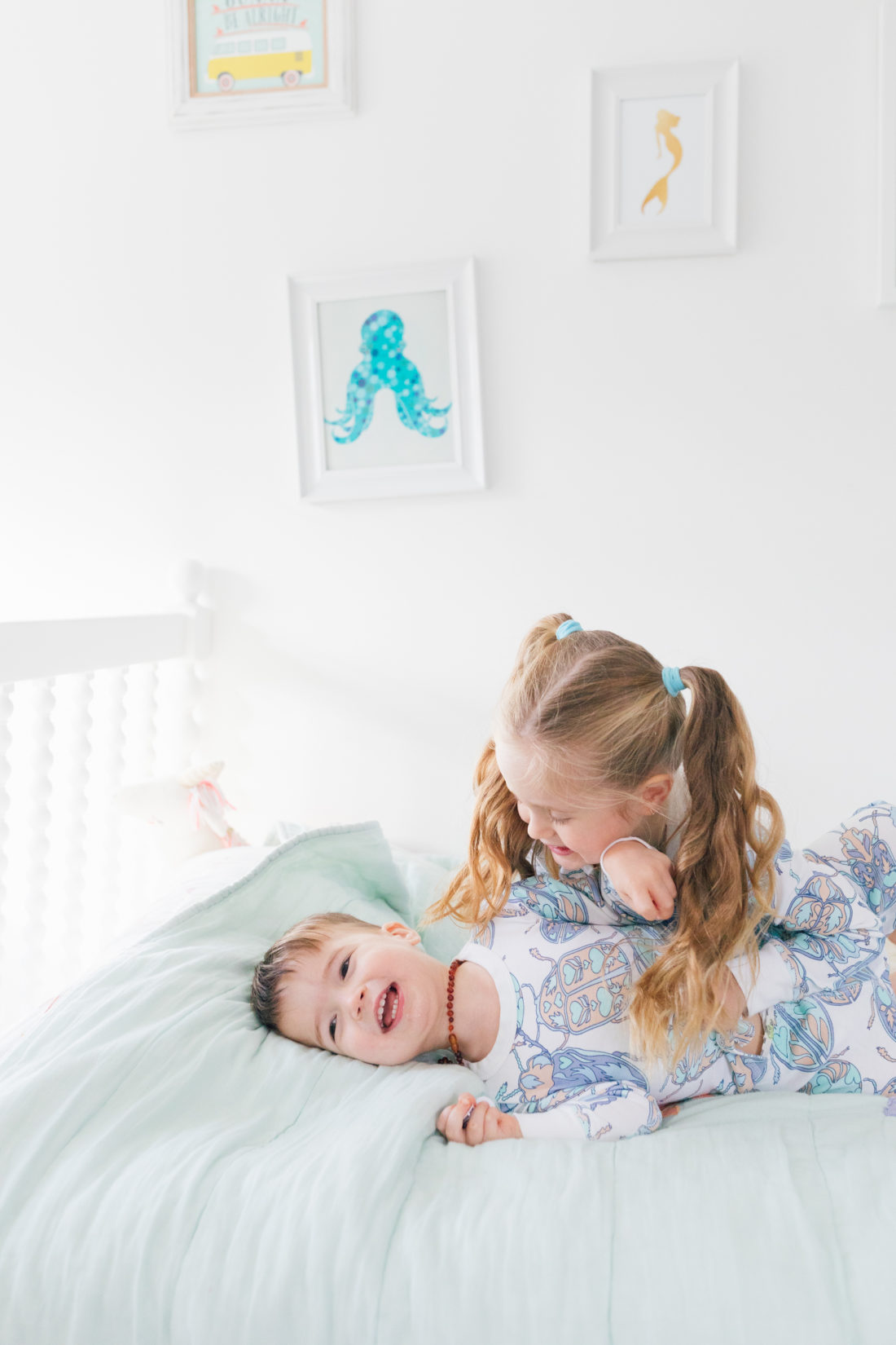 Marlowe Martino gives little brother Major a big hug while wearing matching blue bug pajamas from the Happily Eva After x Masala Baby capsule collection