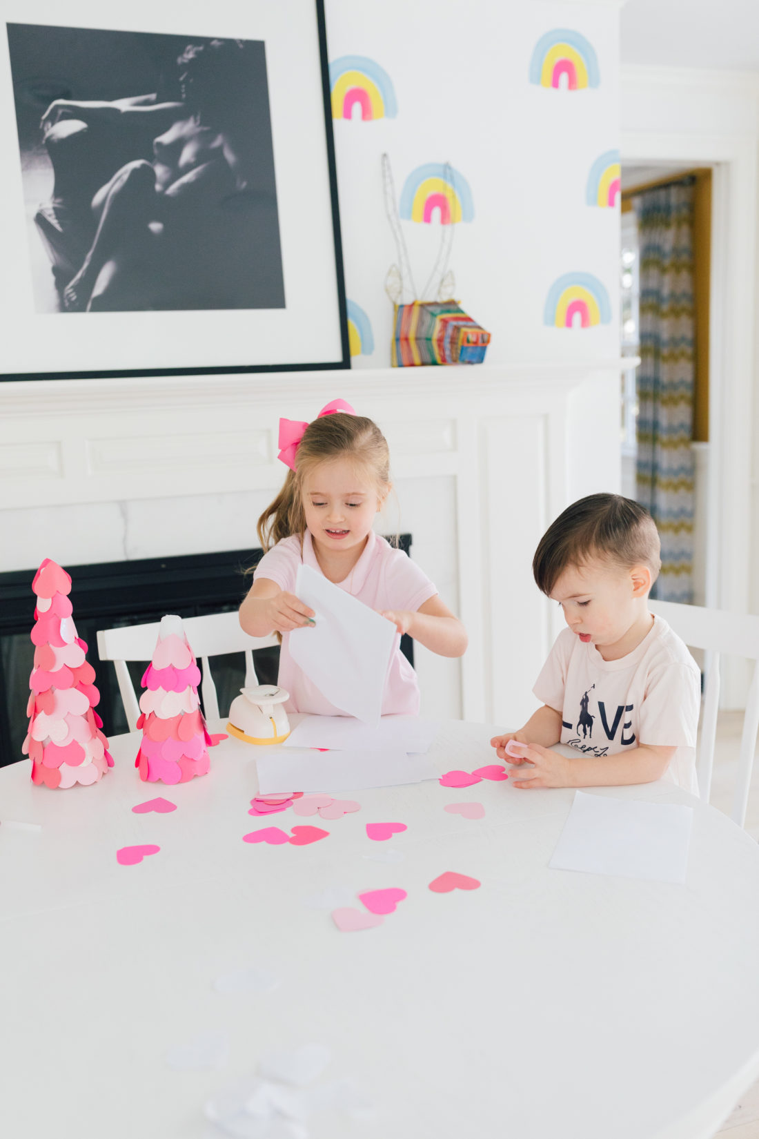 Marlowe and Major martino use a heart hole pumch to create the materials for a valentine's day craft