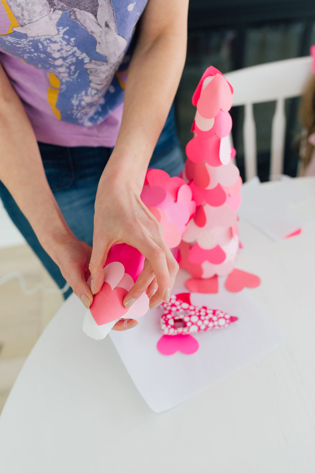 Eva Amurri Martino affixes ombre pink hearts to a foam tree base as part of a valentine's day craft