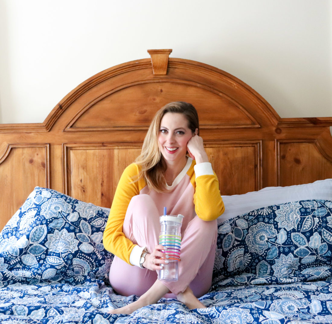 Eva Amurri Martino of Happily Eva After sits on her bed in loungewear