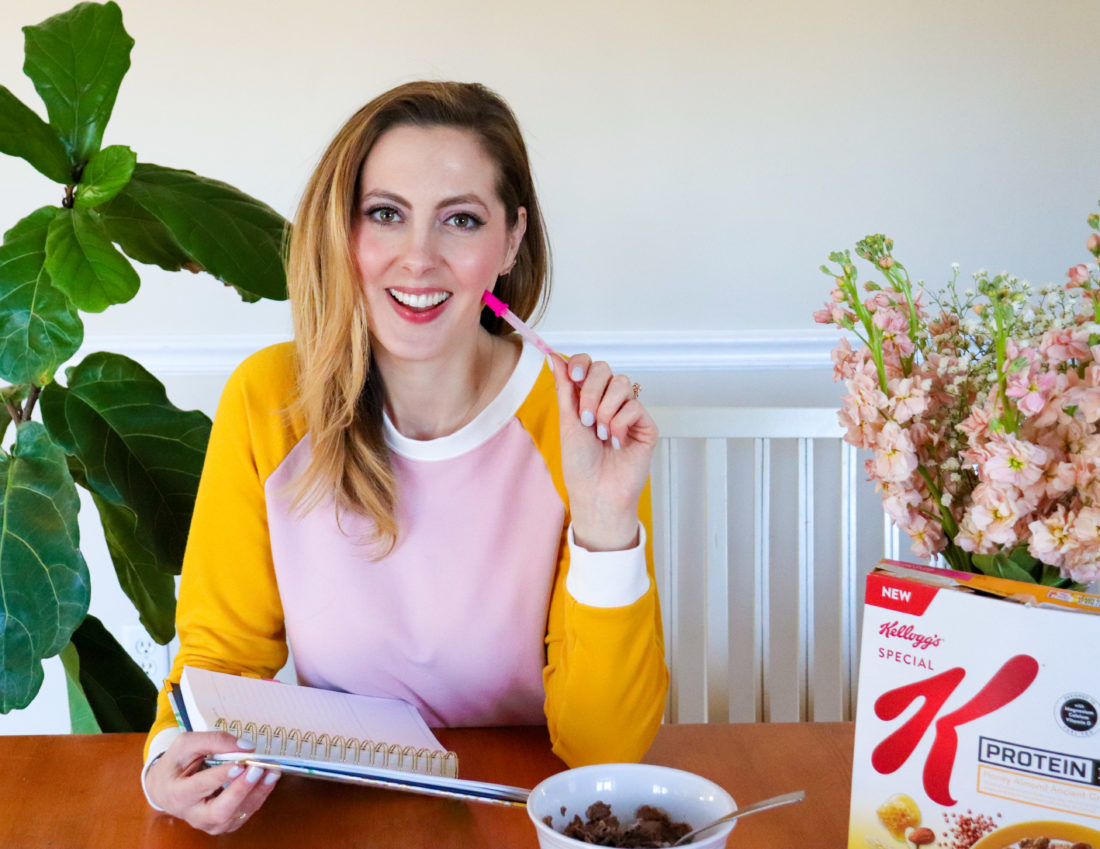 Eva Amurri Martino of Happily Eva After writes in her planner at the kitchen table