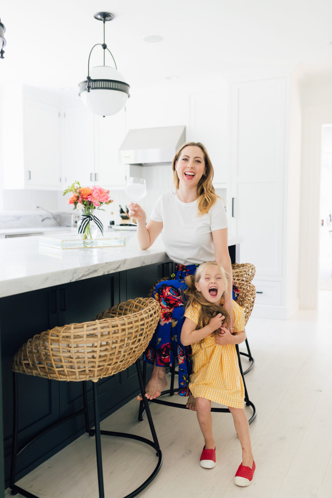 Eva Amurri Martino wears a crisp white t-shirt and a colorful skirt with her daughter Marlowe in her kitchen in Connecticut