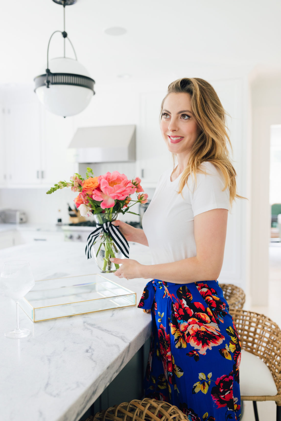 Eva Amurri Martino wears a crisp white t-shirt and a colorful skirt in her kitchen in Connecticut