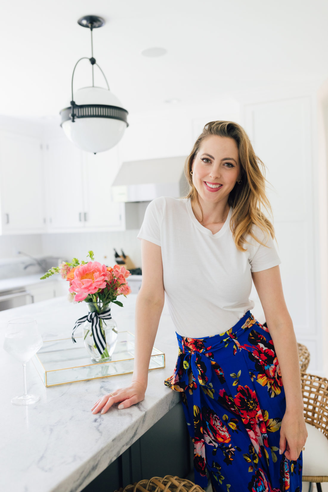 Eva Amurri Martino wears a crisp white t-shirt and a colorful skirt in her kitchen in Connecticut