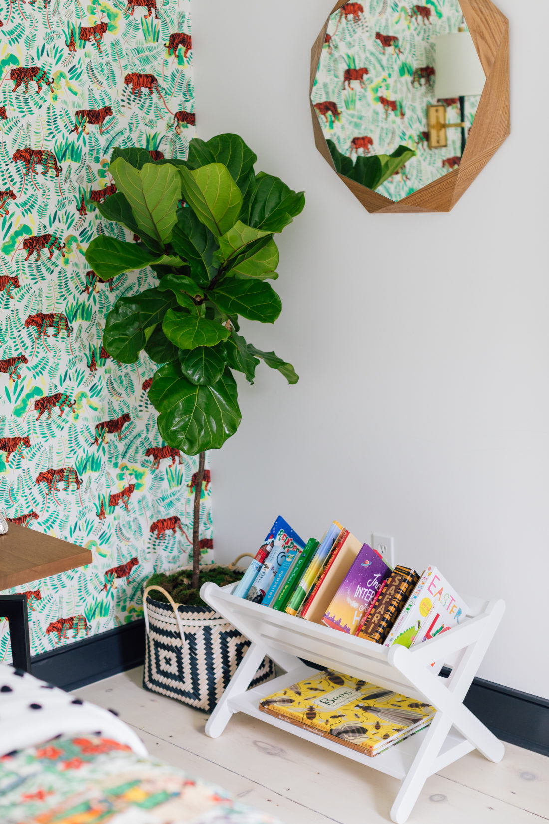 A tree next to colorfully arranged books beneath a mirror in Eva Amurri Martino's son Major's new room.